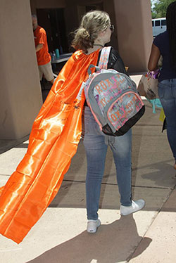 female student with orange cape carrying her new backpack